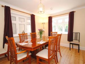 a dining room with a wooden table and chairs at 4 Bed in Studland DC046 in Studland