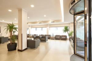 a waiting room with couches and potted plants at Hotel Leonardo da Vinci in Florence