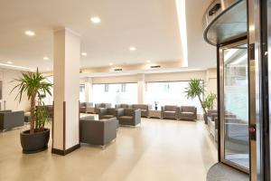 a waiting room with couches and plants at Hotel Leonardo da Vinci in Florence