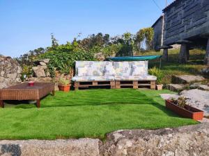 een tuin met een bank, een tafel en gras bij Grupo Gontad A Vixia do Roncudo in A Coruña