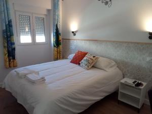 um quarto com uma grande cama branca e 2 almofadas em SG ROOMS em Consuegra