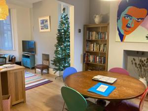 a living room with a table and a christmas tree at 3 bedroom Victorian house close to City centre in Exeter