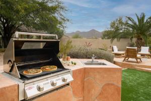 a grill with two pizzas on top of it at Arcadia by AvantStay Breathtaking Oasis in Scottsdale w Pool Hot Tub Game Room in Scottsdale