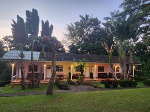 a house with palm trees in front of it at Mon Kiang-Dao Resort in Chiang Dao