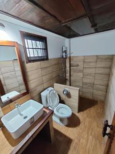 a bathroom with a sink and a toilet and a mirror at Baan Mai Muang Nan in Nan