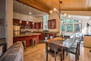 uma cozinha com uma mesa de jantar e um sofá em Moosetrack by AvantStay Cozy Cabin In The Of Tahoe Donner w Hot Tub em Truckee