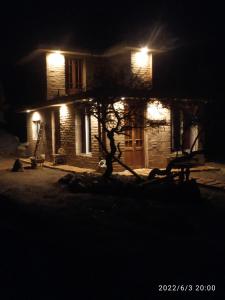 a house lit up at night with a tree in front at Casa de adobe Cuesta blanca in Cordoba +10 photos