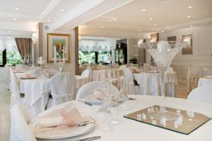 una sala da pranzo con tavoli bianchi e sedie bianche di Hotel Edelweiss a Pescasseroli