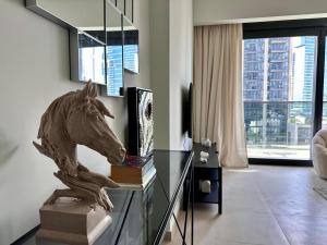 a statue of a horse on a glass table in a living room at Burj Khalifa view - Modern 1BDR apartment in Dubai