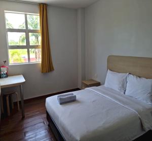 um quarto com uma cama, uma secretária e uma janela em OYO 90901 Santai Morib Hotel em Banting