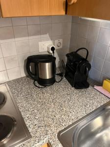 a coffee pot on a counter next to a sink at Chalet Baur in Arosa