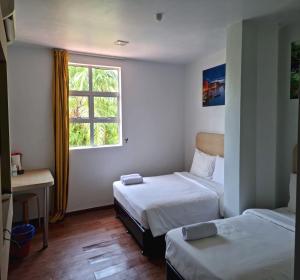um quarto de hotel com duas camas e uma janela em OYO 90901 Santai Morib Hotel em Banting
