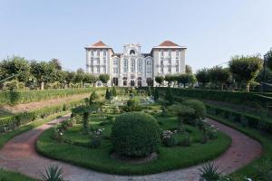 Curia Palace Hotel & Spa في كوريا: مبنى كبير وامامه حديقة