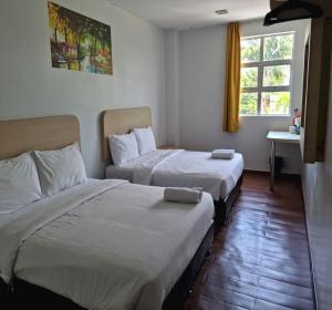 um quarto de hotel com duas camas e uma janela em OYO 90901 Santai Morib Hotel em Banting