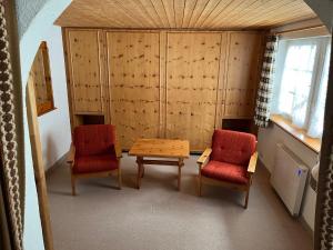 アローザにあるChalet Baurの椅子2脚、テーブル1台、テーブル1台、椅子2脚が備わる客室です。