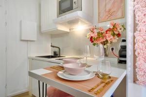 eine Küche mit einem Tisch mit Weingläsern und Blumen in der Unterkunft La Vie en Rose / Jacuzzi in Montgeron