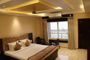 a bedroom with a bed and a large window at Hotel Sweet Villa (Sea View) in Puri