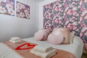 ein Schlafzimmer mit einem Bett mit zwei Herzen und Handtüchern in der Unterkunft La Vie en Rose / Jacuzzi in Montgeron