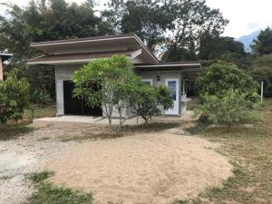 una pequeña casa blanca con un árbol delante en Paradise Hill en Chiang Dao