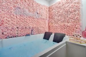 ein Zimmer mit 2 Stühlen und einer Wand aus rosa Blumen in der Unterkunft La Vie en Rose / Jacuzzi in Montgeron
