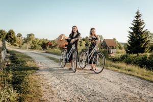 two women walking their bikes down a dirt road at Czar Podlasia agroturystyka in Osłowo