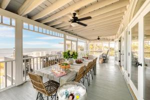 comedor con mesa y sillas en el porche en Haven by AvantStay Luxury Beachfront Home w Pool Gorgeous Patios en Sullivans Island