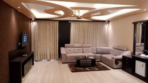 a living room with a couch and a television at Hotel Sweet Villa (Sea View) in Puri