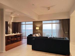 a living room with a black couch and a large window at Waterfront Suites Phuket by Centara NEW in Phuket Town