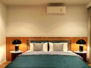 a bedroom with a green bed with two lamps at Waterfront Suites Phuket by Centara NEW in Phuket Town +34 photos