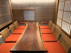 a conference room with a wooden table and chairs at Ikeda Onsen Ryokan Tachikawa in Ogaki