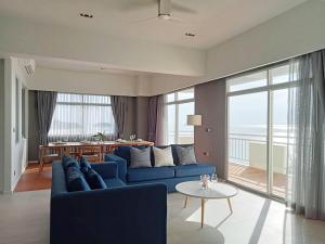 a living room with a blue couch and a table at Waterfront Suites Phuket by Centara NEW in Phuket Town