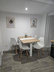 a dining room with a table and white chairs at Appartement rénové proche gares d'Orléans et Fleury les aubrais in Orléans