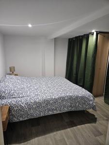 ein Schlafzimmer mit einem Bett mit einer schwarzen und weißen Decke in der Unterkunft Appartement rénové proche gares d'Orléans et Fleury les aubrais in Orléans