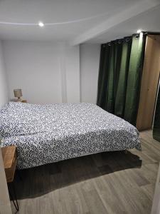 - une chambre avec un lit et une couverture noire et blanche dans l'établissement Appartement rénové proche gares d'Orléans et Fleury les aubrais, à Orléans