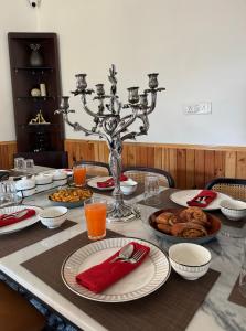 einen Tisch mit Teller mit Lebensmitteln und einem Kronleuchter in der Unterkunft Mahantam Luxury Stays in Nagar
