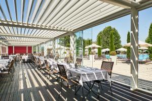 a restaurant with tables and chairs on a deck at Living Place Hotel in Villanova
