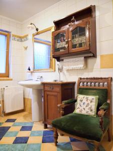 a bathroom with a sink and a chair with a pillow at Guest House Bitter in Braslovče