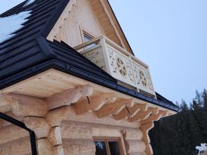 a roof of a log cabin with a window at Domek w Witowie in Witów