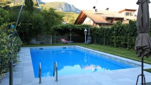 een zwembad in een tuin met een huis bij Ferienwohnungen Palma in Cortaccia