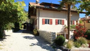 een huis met rode luiken op een straat bij Ferienwohnungen Palma in Cortaccia