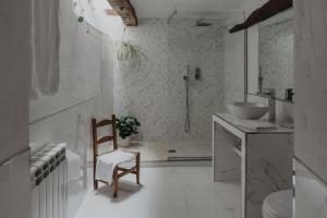 y baño con ducha, lavabo y silla. en Casa rural Villapajar, en Villasur de Herreros