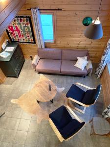 uma vista superior de uma sala de estar com um sofá e cadeiras em Rentorakka em Kittilä