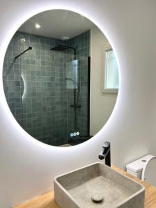 une salle de bain avec un lavabo et un miroir dans l'établissement Maison avec piscine et jardin privatifs - un séjour au calme, à Biscarrosse