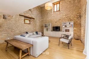 ein Wohnzimmer mit einem weißen Sofa und einem Tisch in der Unterkunft Charming stone Villa CX with large 50m2 heated pool in Brtonigla
