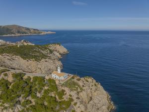 a church on the side of a cliff near the ocean at Apartamento Bellavista Puerto 3 in Cala Ratjada