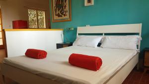1 cama grande con 2 almohadas rojas. en Villa ai Pini di ArgonautiVacanze en Procchio