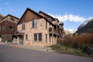 a large stone building with mountains in the background at Sugarloaf by AvantStay Telluride Home In Great Location Near the Slopes in Telluride
