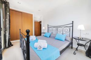 a bedroom with a bed with blue pillows at Apartamento Bellavista Puerto 4B in Cala Ratjada