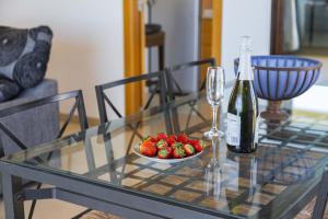 a glass table with a bowl of strawberries and a bottle of wine at Apartamento Bellavista Puerto 4B in Cala Ratjada +26 photos