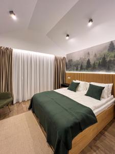 um quarto com uma cama grande e um cobertor verde em Moon Village Comarnic em Sinaia